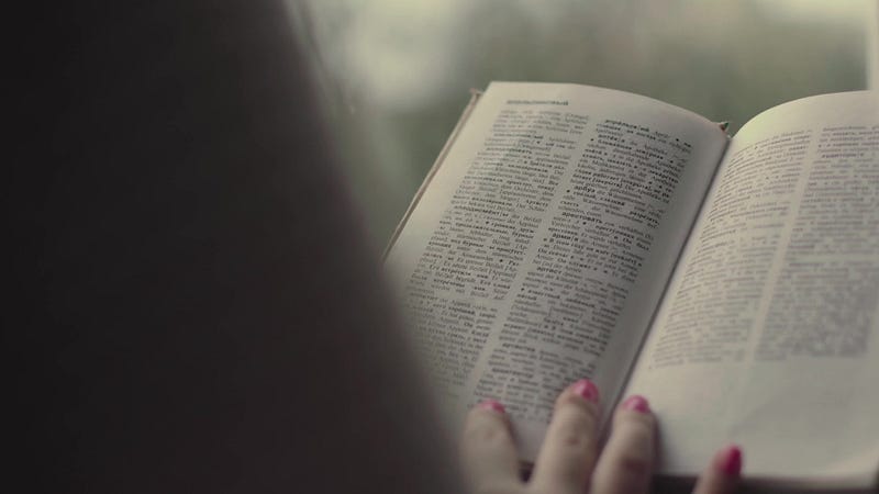 Woman reading a book with a focus on genetics.